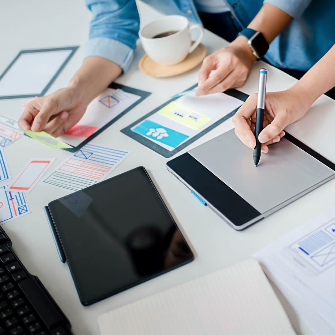 Eine Gruppe von Menschen arbeitet an einem Tablet, inspiriert von den angesagtesten Webdesign-Trends im Jahr 2024.