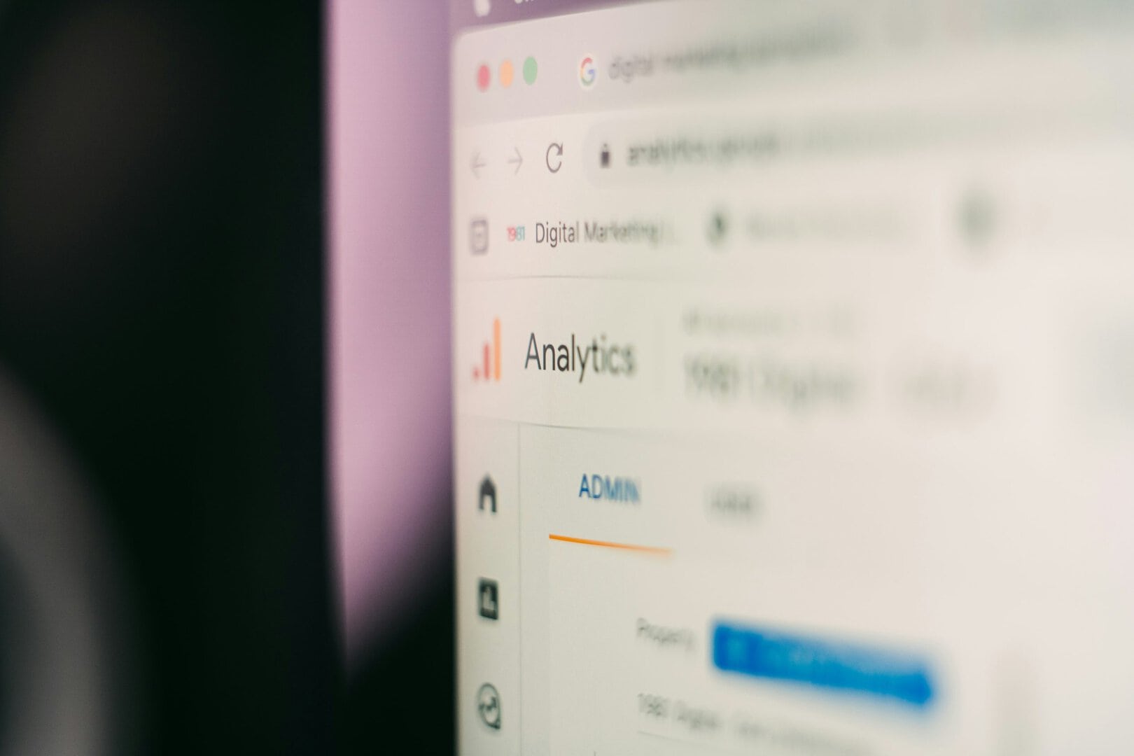 Eine unscharfe Nahaufnahme eines Computerbildschirms, auf dem das Google Analytics-Dashboard angezeigt wird, mit dem Analytics-Logo, dem Navigationsmenü auf der linken Seite und einem hervorgehobenen Call-to-Action-Button im Blick.