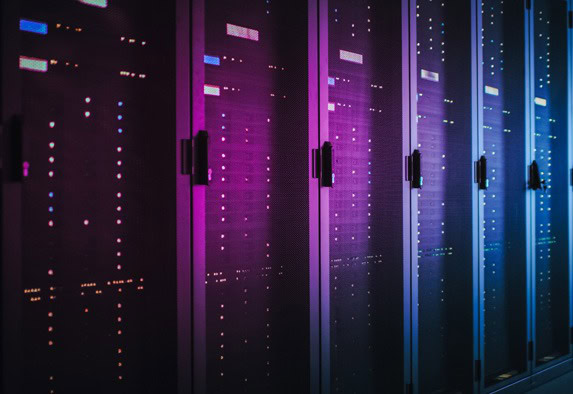 Eine Reihe von Serverschränken mit blinkenden Lichtern hinter Gittertüren, beleuchtet von violetter und blauer Beleuchtung, in einem modernen Rechenzentrum, das auf Domain-Management und Hosting-Lösungen spezialisiert ist.