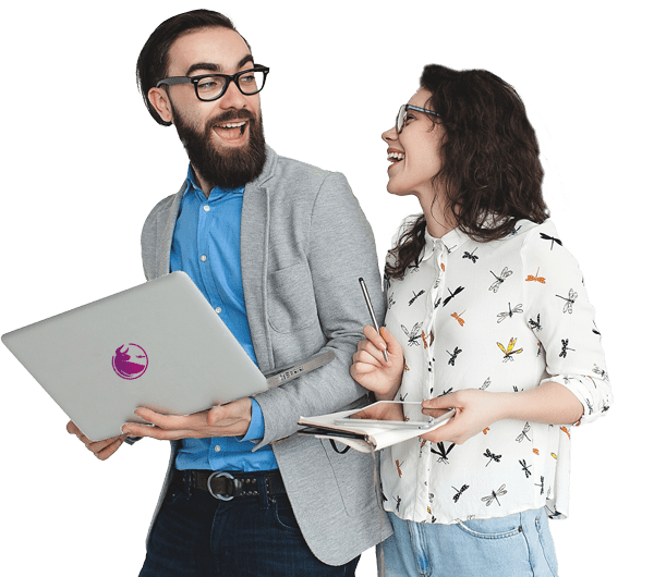 Ein bärtiger Mann mit einem Laptop und eine lächelnde Frau mit Brille, die ein Notizbuch und einen Stift in der Hand hält, stehen zusammen, schauen sich an und lachen.