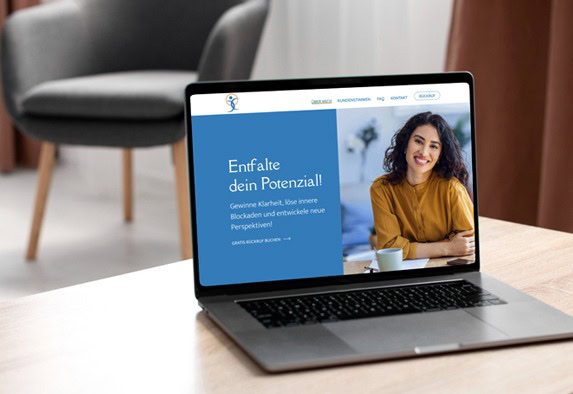 Ein Laptop auf einem Holztisch zeigt eine Website mit einer lächelnden Frau und dem deutschen Text Entfalte dein Potenzial! in Blau und Weiß, was auf ein Coaching zur persönlichen Entwicklung hindeutet. Im Hintergrund sind ein Stuhl und ein Vorhang zu sehen.