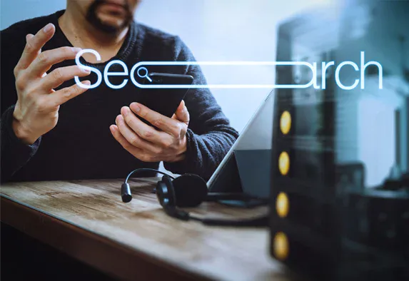 Eine Person mit einem Smartphone an einem Schreibtisch mit Laptop und Headset, die die Arbeit einer SEO-Agentur Rastatt hervorhebt, mit einer transparenten „Search“-Balkengrafik, die im Vordergrund eingeblendet ist. Eine Person mit einem Smartphone an einem Schreibtisch mit Laptop und Headset, die die Arbeit einer SEO-Agentur Rastatt hervorhebt, mit einer transparenten "Search"-Balkengrafik, die im Vordergrund eingeblendet ist.