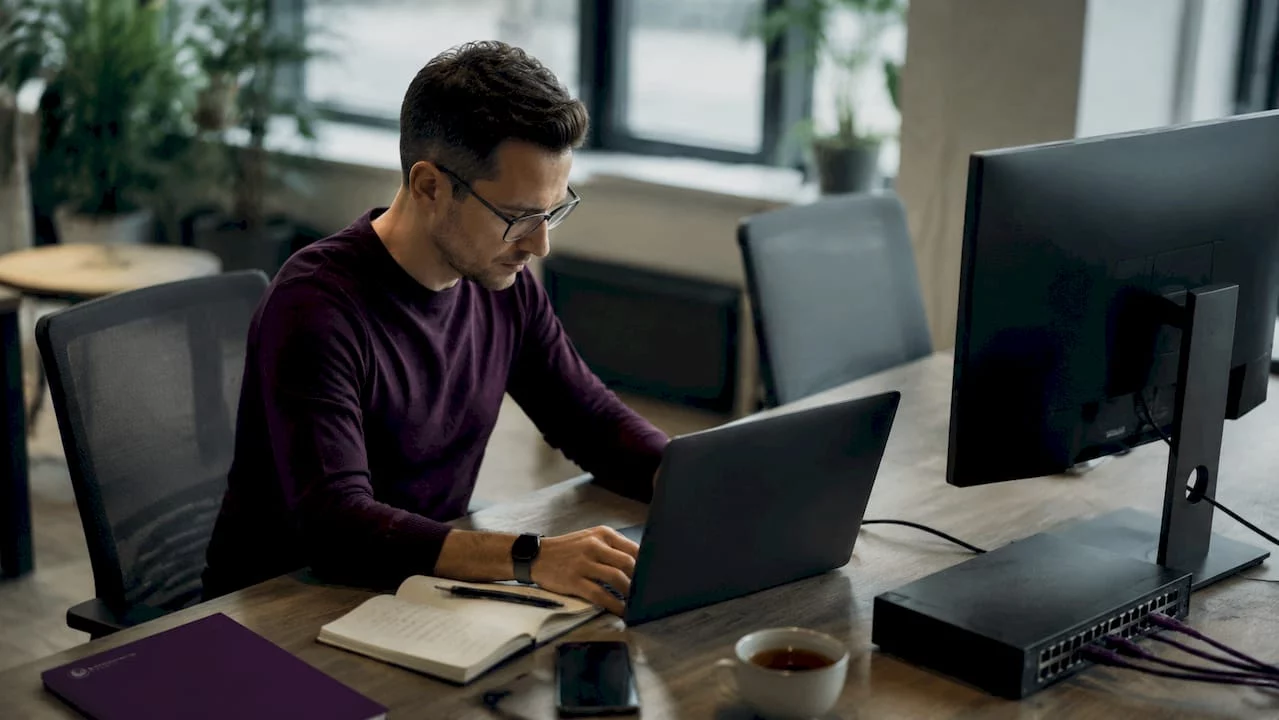 Ein IT-Experte überwacht und betreut am Schreibtisch die Server-Infrastruktur seines Unternehmens.