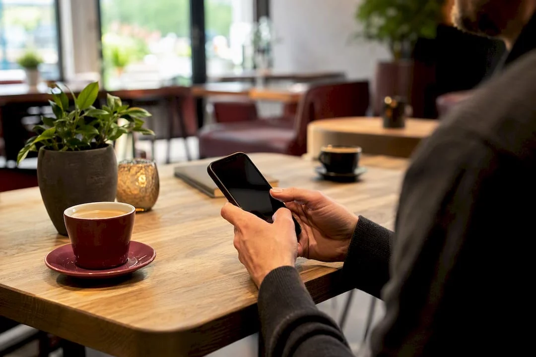 Jemand hält ein Smartphone in den Händen und liest sich eine Kundenbewertung durch.